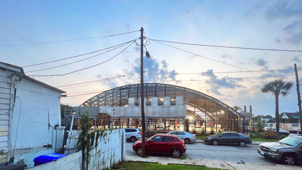 DynaDome | A parking lot with a retractable enclosure in front of a building.