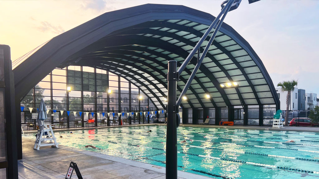 DynaDome | An indoor swimming pool with a retractable glass roof.