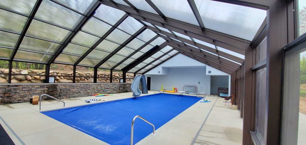 DynaDome | An indoor swimming pool with a retractable glass roof.