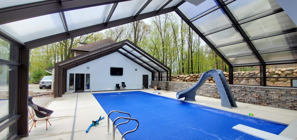 DynaDome | A house with a swimming pool and a retractable enclosure.