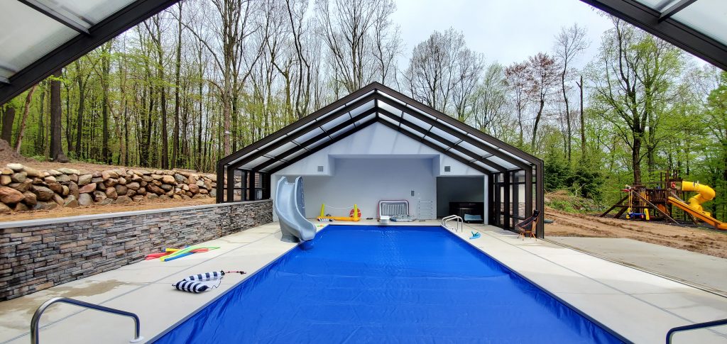 DynaDome | A backyard swimming pool with a retractable enclosure.