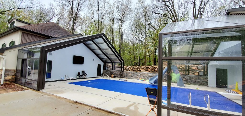 DynaDome | A swimming pool in a house with a retractable glass enclosure.