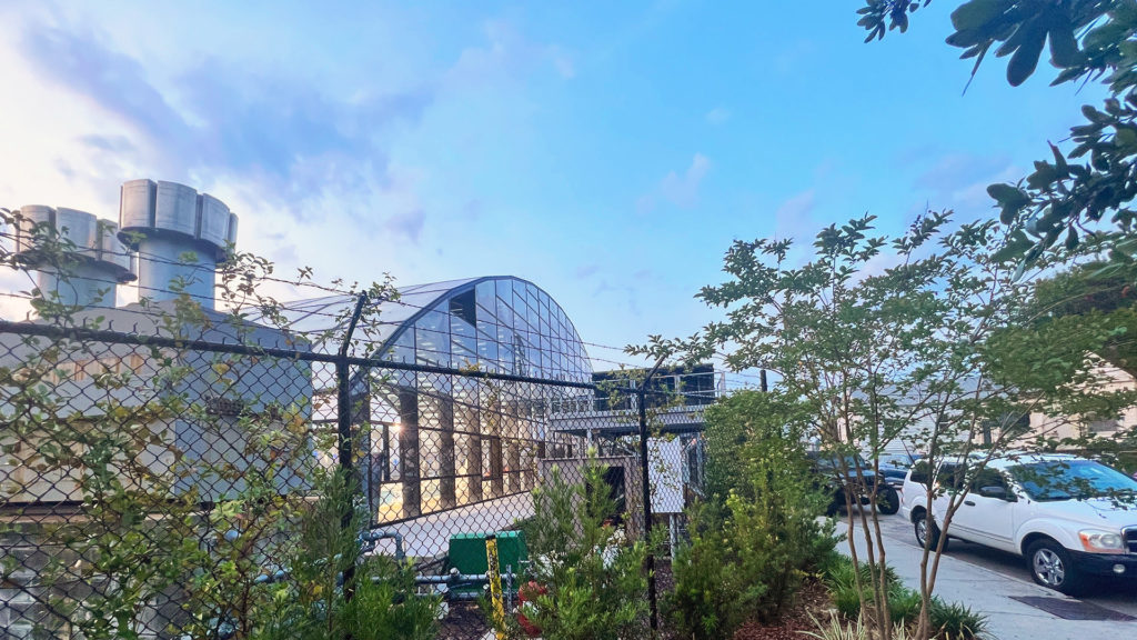 DynaDome | A car is parked in front of a retractable greenhouse enclosure.