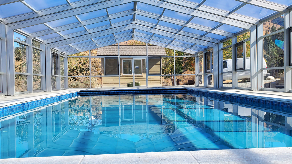 DynaDome | A retractable glass enclosure reveals a swimming pool within a house.