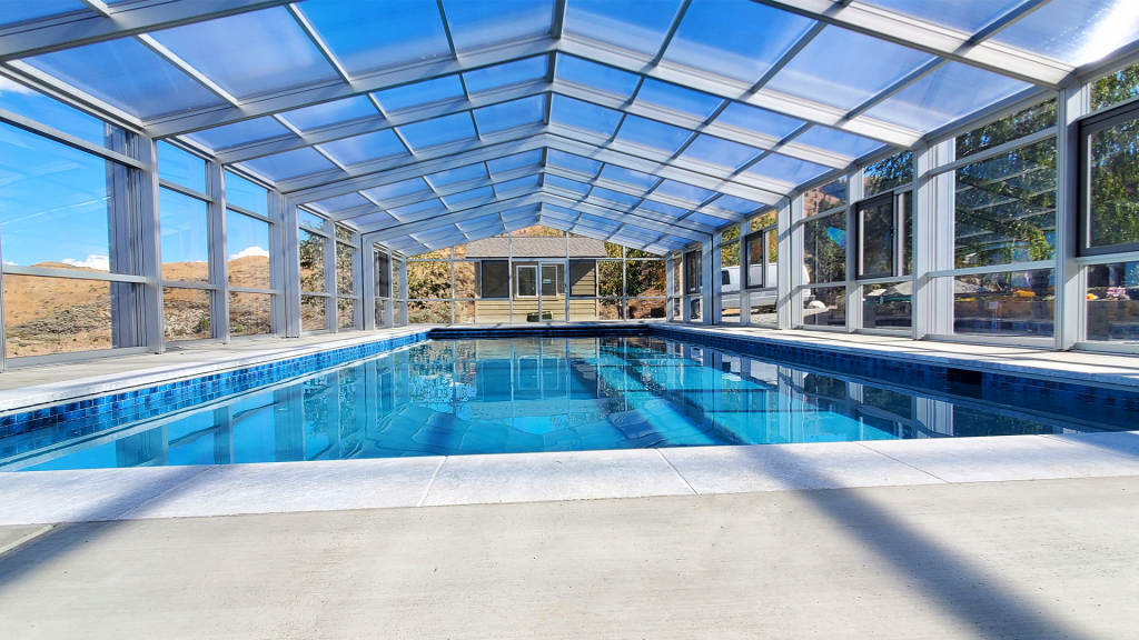 DynaDome | A retractable glass enclosed swimming pool in a house.