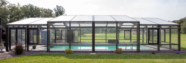 DynaDome | A glass enclosed swimming pool in a backyard, perfect for a tranquil home oasis.