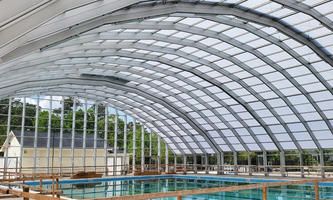 DynaDome | An indoor swimming pool with a glass roof, providing a luxurious and refreshing addition to your home.